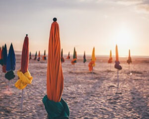 Parasols colorés fermés sur la plage de Deauville au coucher du soleil sur