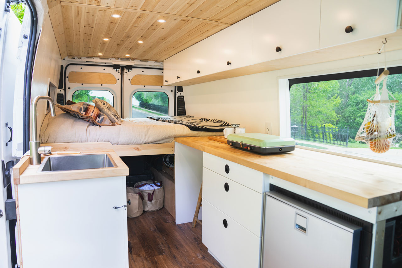 aménagement d'un van aménagé avec un lit et une cuisine