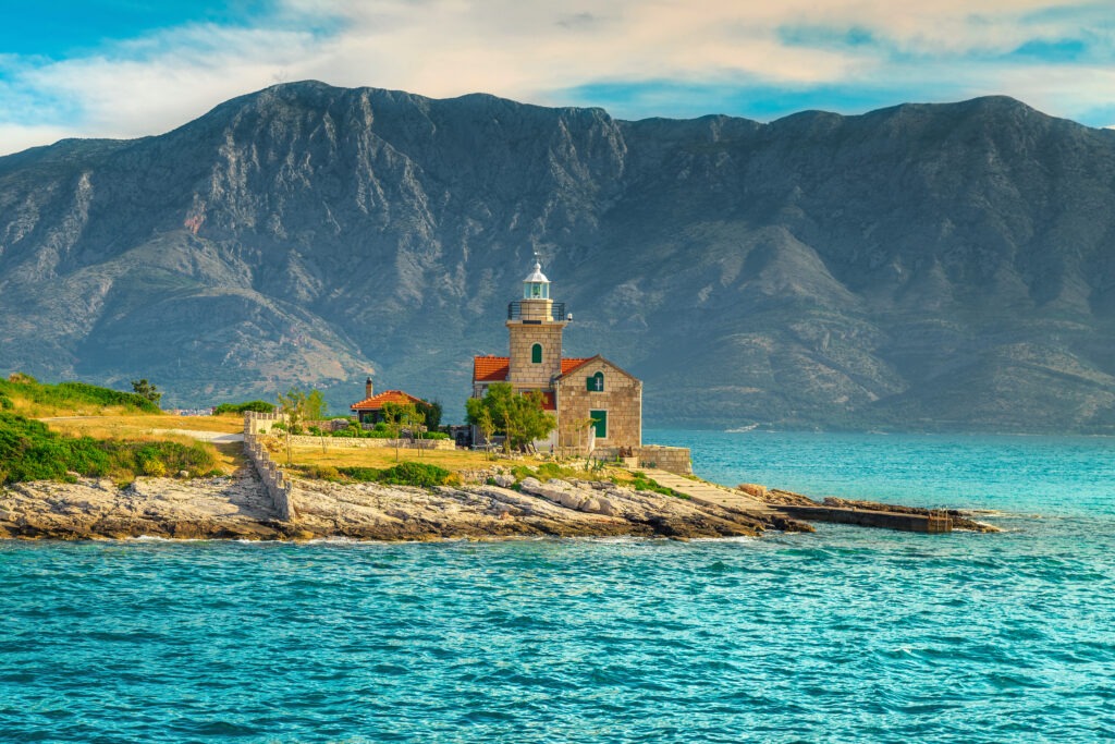 Phare sur le bord de la mer Adriatique avec des montagnes en fond