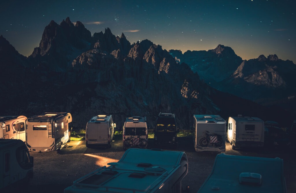 Camping-cars stationnés sur une aire de camping-car face aux montagnes 