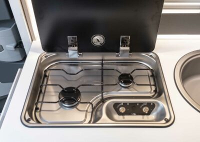 Cuisine équipée avec gazinière dans un camping-car à louer à Angers